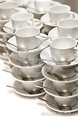 Stacked empty teacups with teaspoons Stock Photo