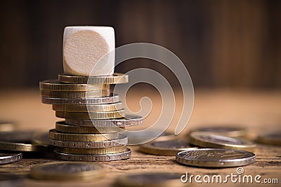 Stacked euro coins with empty cube Stock Photo