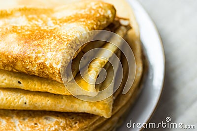Stacked folded crepes on white plate on linen cloth background, closeup, breakfast Stock Photo