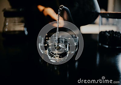 stacked glasses, in a cafe, being poured mineral water using a teapot, Aceh Stock Photo