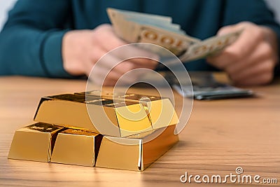 Stacked gold bars and man counting money, closeup. Space for text Stock Photo