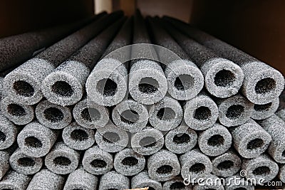 Stacked insulation for pipes of polyethylene foam in warehouse Stock Photo