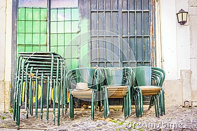 Stacked green tables and chairs on Lisbon street, Portugal Stock Photo