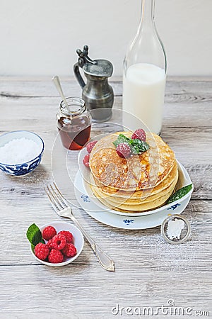 Stacked pancakes raspberries mint and sugar on white plate Stock Photo