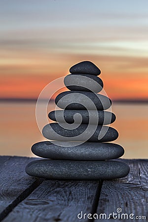 Stacked pebbles on a wooden surface Stock Photo