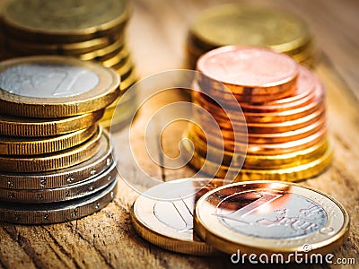 Stacked shiny white and golden Euro coins of different value on wood background, finances, investment, stock, savings concept Stock Photo