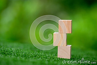 Stacking blank wooden cubes on green background with copy space for input wording and infographic icon. Empty brown wooden object Stock Photo