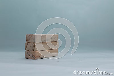 Stacking 3 rectangle empty wooden blocks on table with light turquoise background for own customer text or letters. Idea of Stock Photo