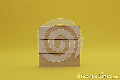 Stacking 3 rectangle empty wooden blocks on table with yellow background for own customer text or letters. Idea of environment, Stock Photo