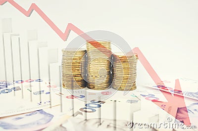 Stacks of coins, Ukrainian hryvnia and a graph of the economic decline. Business crisis and collapse concept. Stock Photo