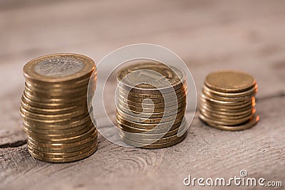 Stacks of coins on wooden tabletop Stock Photo