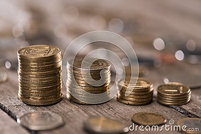 Stacks of coins on wooden tabletop Stock Photo