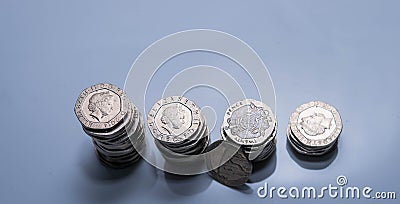 Stacks of different British coins on a white background. Editorial Stock Photo