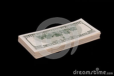 stacks of hundred dollar bills on top of each other on a black surface Stock Photo