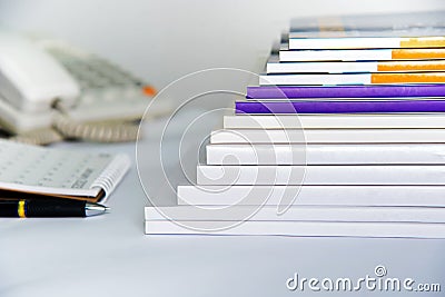 Stacks of magazines lined up near the phone. Pens and notebooks in the library Stock Photo