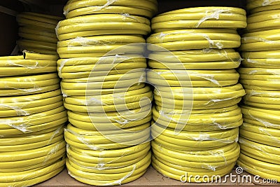 Stacks of rolls yellow pvc plastic pipe on the counter in the store Stock Photo