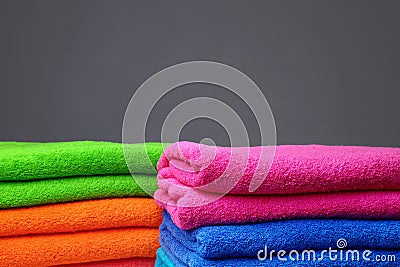 Stacks of soft color towels on grey background Stock Photo