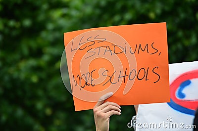 Less Stadiums, More Schools Handwritten Sign of Protest Stock Photo