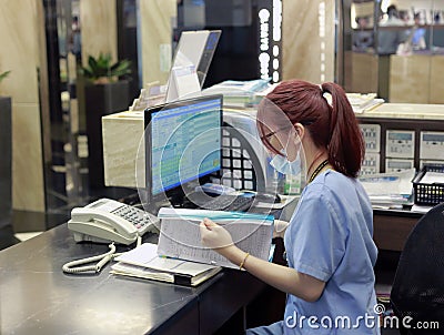 Staff of abc dental hospital working next to computer Editorial Stock Photo