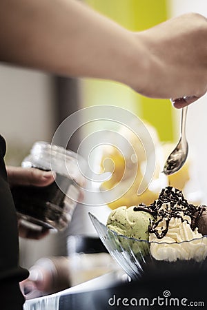 Staff making italian gelato ice cream sundae in modern shop Stock Photo