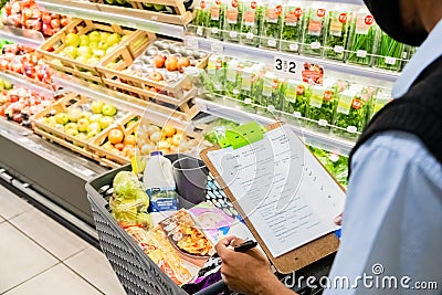 Staff member picking grocery products from shelf for express home delivery service at local Pick n Pay supermarket Editorial Stock Photo