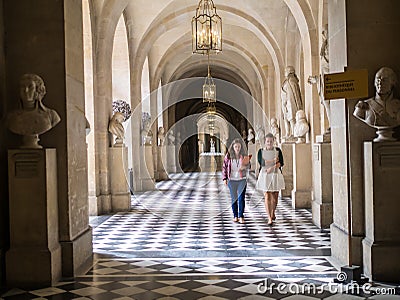 Staff members walk down Versailles Palace corridor, France. Editorial Stock Photo