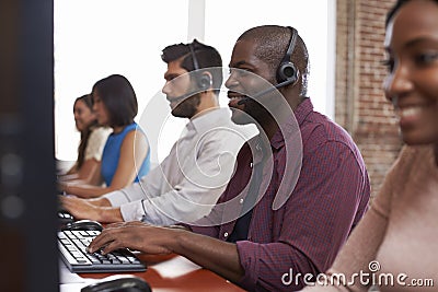 Staff Working In Busy Customer Service Department Shot Stock Photo