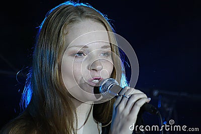 On stage, the musicians pop-rock group Spearmint and singer Anna Malysheva. red . Red headed Glam Rock Girl singing. Editorial Stock Photo