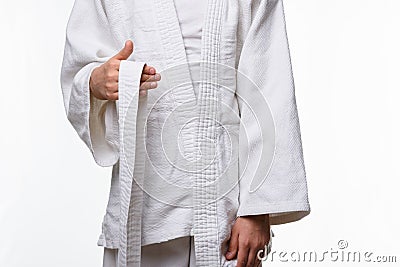 Stages of correct tying of the belt by a teenager on a sports kimono, step one Stock Photo