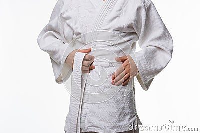 Stages of correct tying of the belt by a teenager on a sports kimono, step two Stock Photo