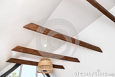 Stained brown decorative wooden beams in home living room white color ceiling. Stock Photo