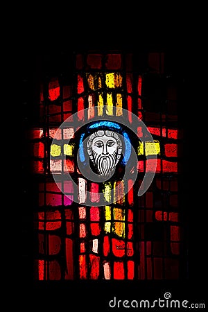 Stained glass on a black background in the shape of a cross in the Cathedral of Peter and Paul in Wissembourg. Editorial Stock Photo