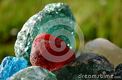 Stained glass from old glassworks smoothed and rounded in a mountain river collected by children beautifully stand out in the sun Stock Photo