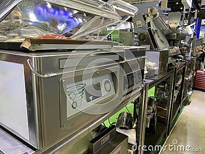 Stainless industrial-type vacuum packaging machine on trade fair exhibition display. Editorial Stock Photo