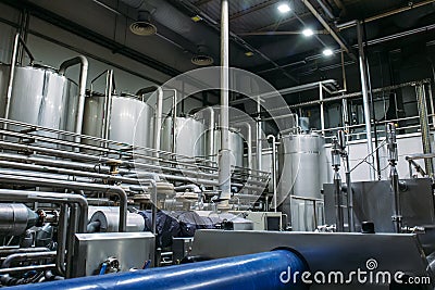 Stainless steel brewing equipment : large reservoirs or tanks and pipes in modern beer factory. Brewery production Stock Photo