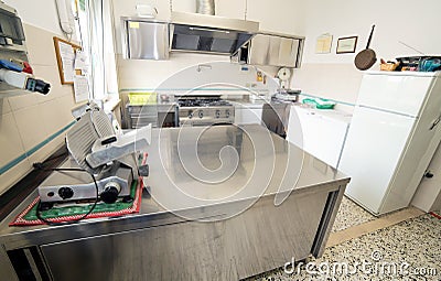 stainless steel kitchen with gas stove and an industrial meat slicer Stock Photo
