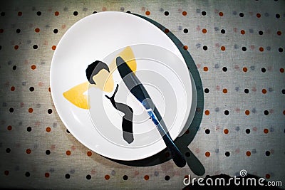 Stainless steel knife in a white breakfast plaste on a dotted table textile Stock Photo