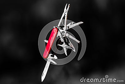 Stainless steel pocketknife with silver finish on blade and red handle in blurry background Stock Photo