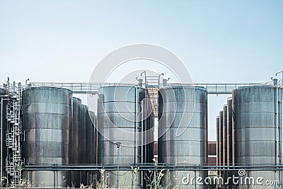 Stainless steel storage tanks or vats for wine fermentation and maturation in modern winery factory production Stock Photo