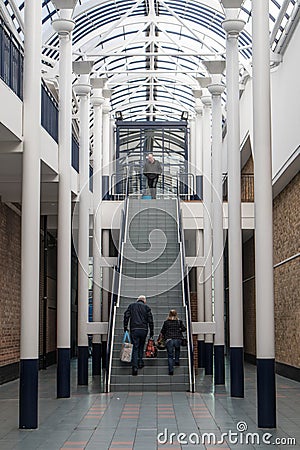 Staircase in building arcade showing couple starting to walk up the stairs with shopping bags Editorial Stock Photo