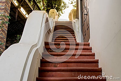 A staircase at a monastery, with a brownish floor and sunlight. Stock Photo