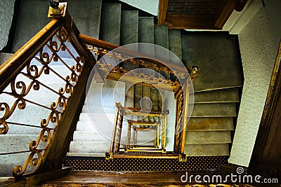 Staircase stairway. Old vintage squared spiral multi-flight stairs stairway with brown wood and metal handrails Stock Photo