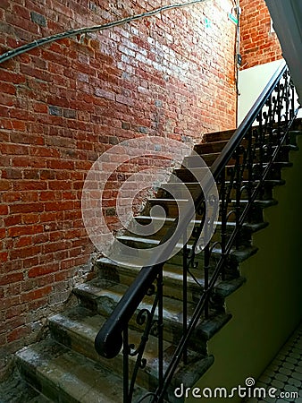 Staircase upstairs and railings at the entrance. Brick wall repair. Steps before renovation. Stock Photo