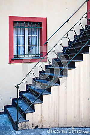 Stairway, Iron Railing and Red-Framed Window Stock Photo