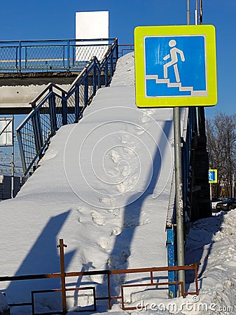 Stairway overhead pedestrian crossing covered with snow. Sign crosswalk. Repair work Stock Photo