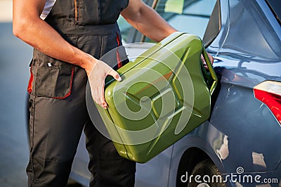 Stalled car filling with gasoline by professional worker. Stock Photo