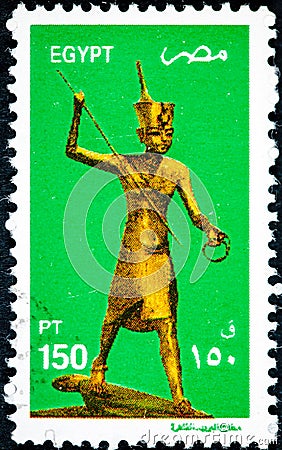 Stamp printed in Egypt shows King Tutankhamen as Harpooner, a Golden Statue of King Tutankahamen Editorial Stock Photo