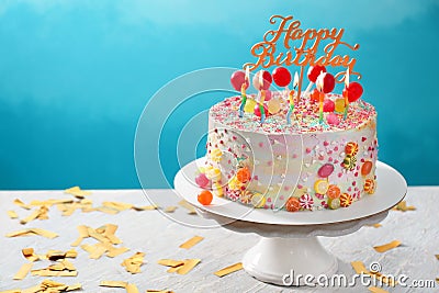 Stand with beautiful tasty birthday cake on table against color background Stock Photo