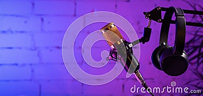 stand with microphone and headphones on brick wall background. online radio and podcasting concept. sound recording Stock Photo