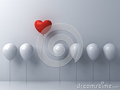 One red heart balloon flying away from other white balloons on white wall background Stock Photo